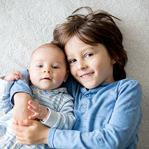 Boy cuddling a baby